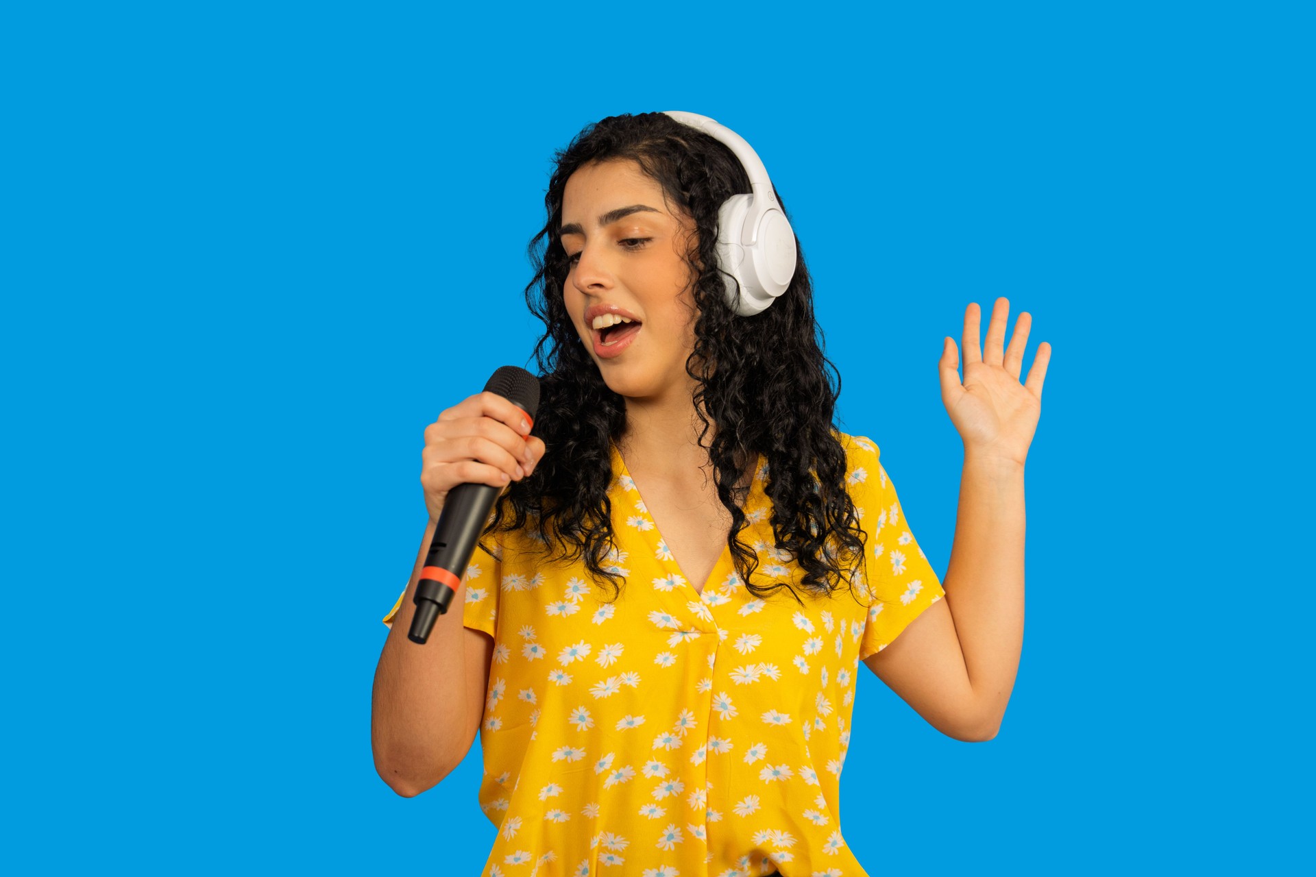 Young adult woman enjoying singing with microphone and headphones