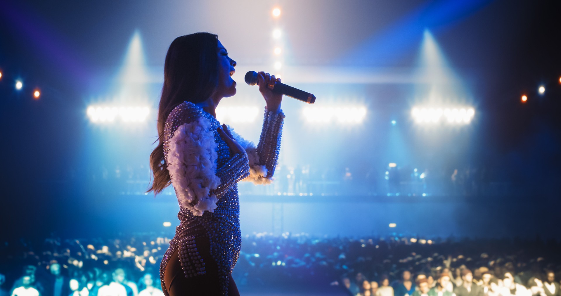 Talent Show Performance: Portrait of a Young Female Pop Singer on a Stage with Colorful Neon Lighting. Musician Singing a Powerful Solo, Poring Her Heartfelt Emotions into Beautiful Music